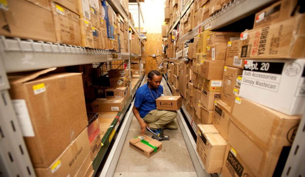 anh nhân viên áo xanh đang xử lý hàng tồn trong kho