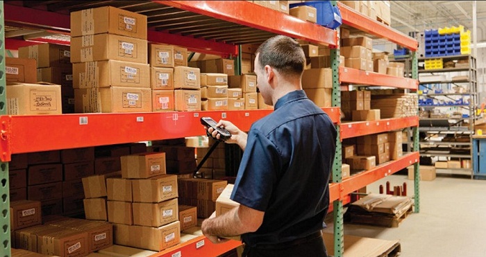 anh nhân viên áo xanh đen đang check hàng tồn